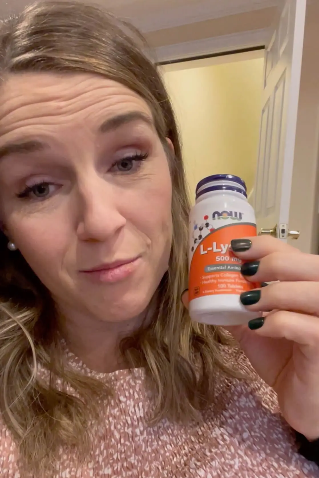 Close-up of woman holding a bottle of L-Lysine, a natural supplement known for supporting immune function and treating cold sores.